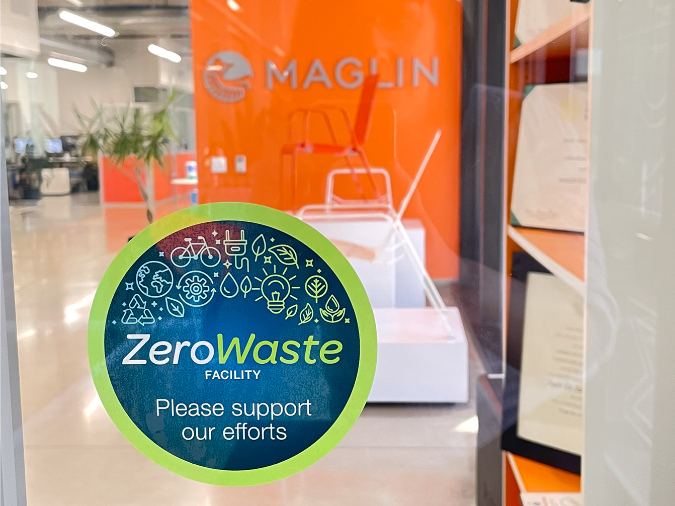 Zero Waste sticker on office door with Maglin logo on orange wall in background