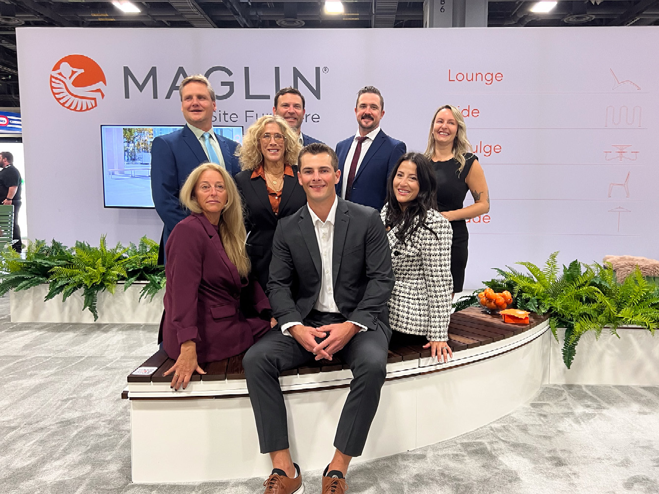 Maglin sales team at ASLA tradeshow sitting on CANOE planter with Ogden Benches