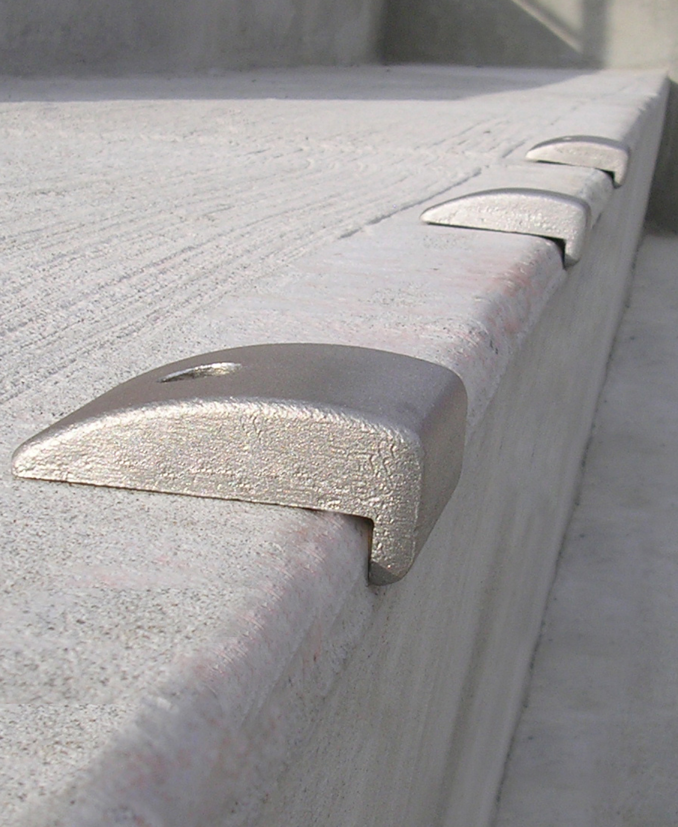 The 300 Skate Deterrent - Wall Mount is installed along the edge of concrete surfaces to prevent skateboarding, making it suitable for skateparks or similar structures.