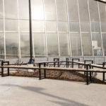 Students walking past modular Ogden bench seating with mitered corners around plantings