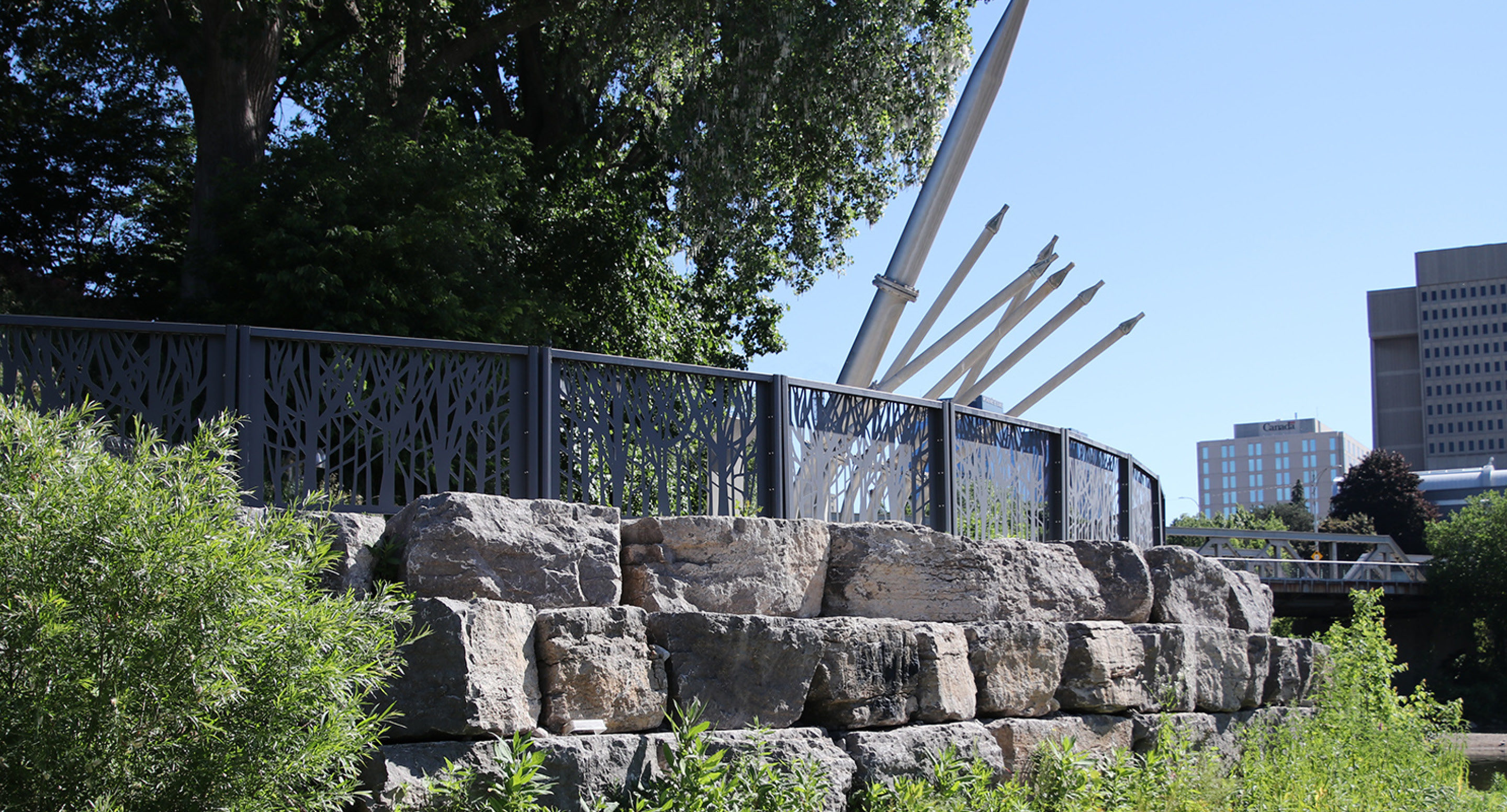 Custom FLEXX panels on rocks edge with trees and pipes
