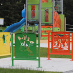 Custom artwork bike racks painted green, orange and yellow at park
