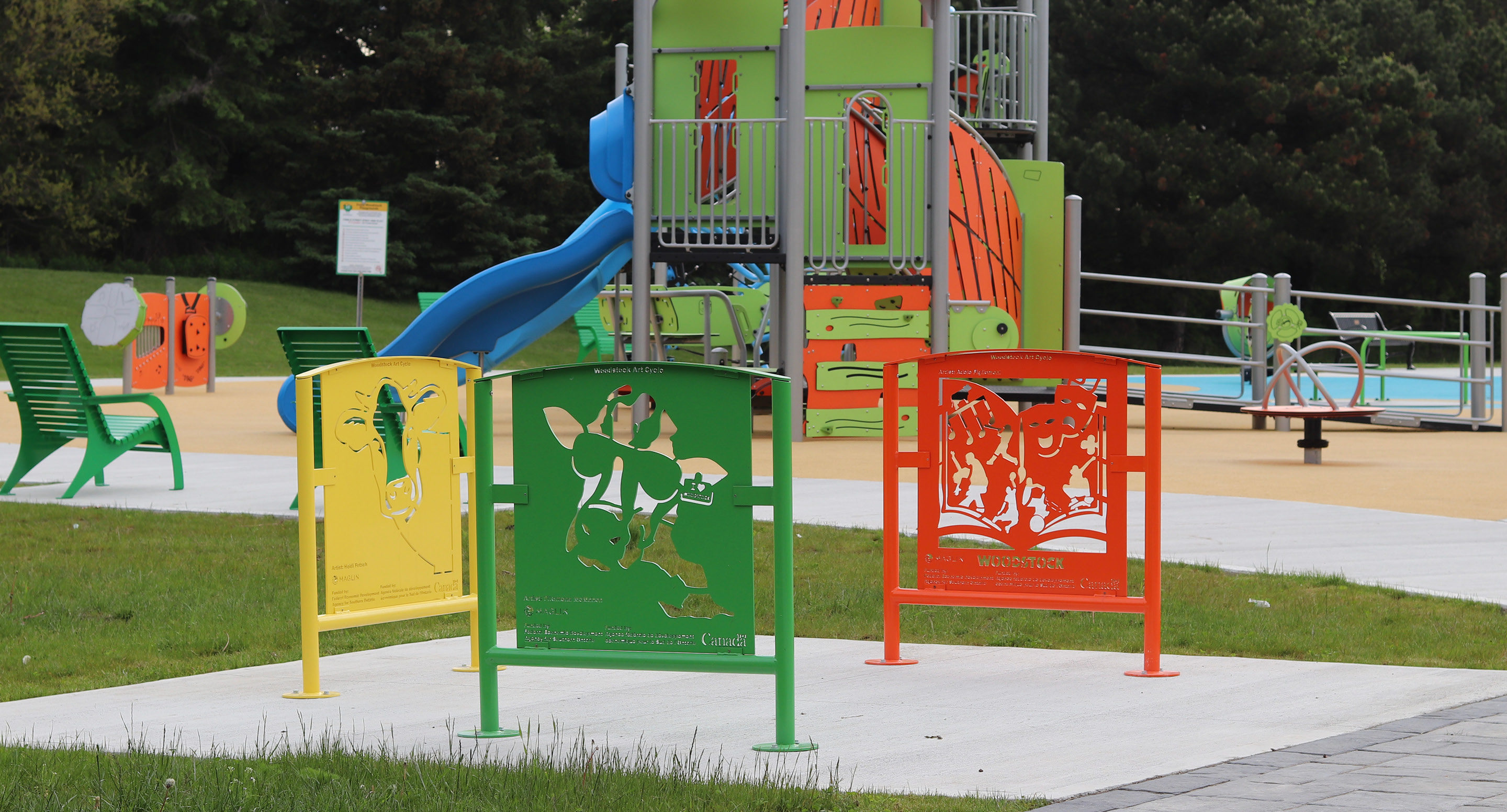 Custom artwork bike racks painted green, orange and yellow at park