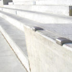Concrete steps with metal skate deterrents installed along the edges, preventing skateboarding or grinding activities.