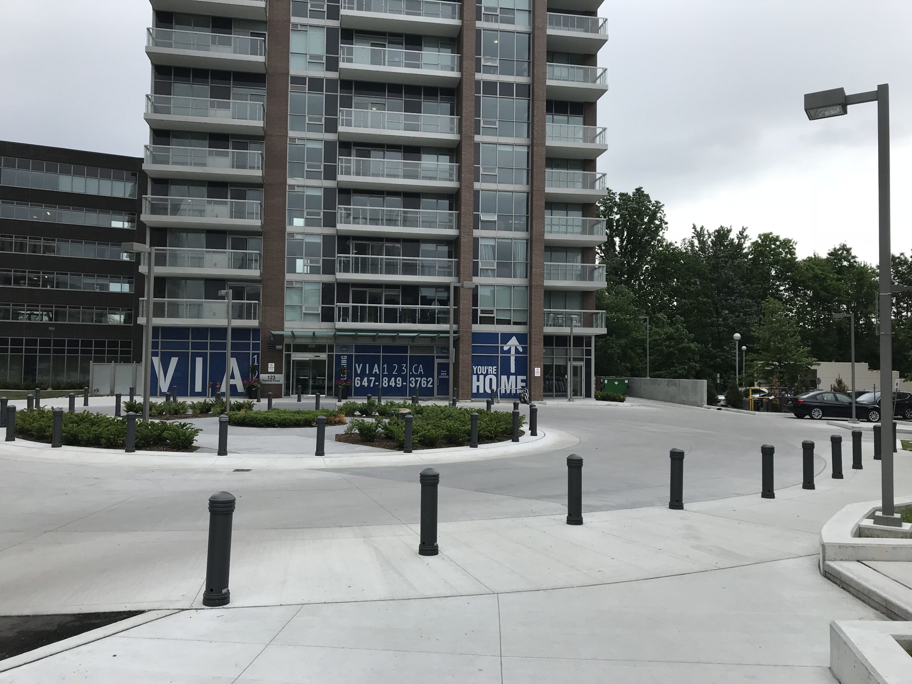 Un immeuble d'appartements moderne de taille moyenne avec des balcons, des fenêtres au rez-de-chaussée portant l'inscription 