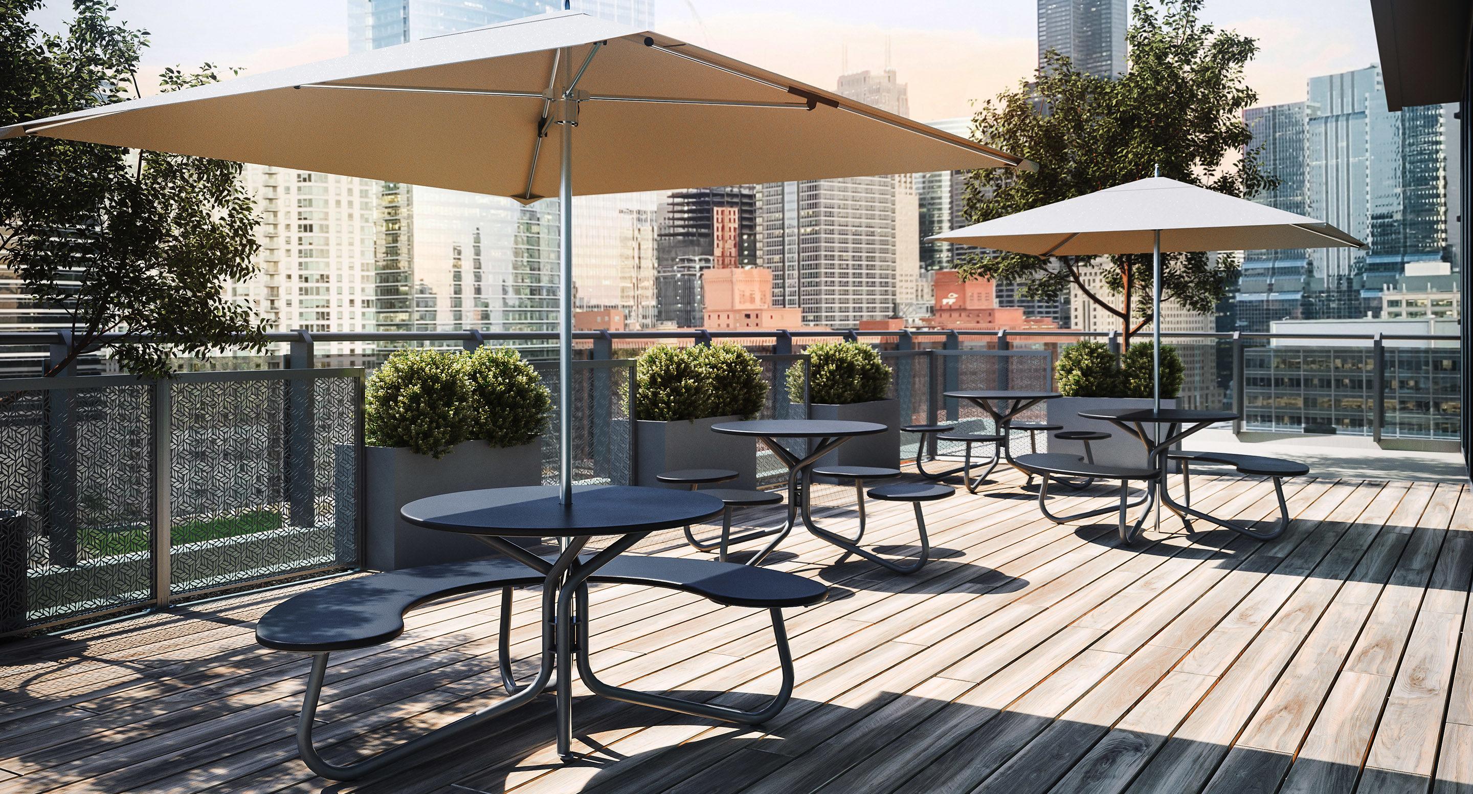 maglin_mtb-2800-fava-cluster-seating-4 Outdoor rooftop seating area with round picnic tables, umbrellas, potted plants, and a city skyline in the background. The wooden deck is empty and sunlit.