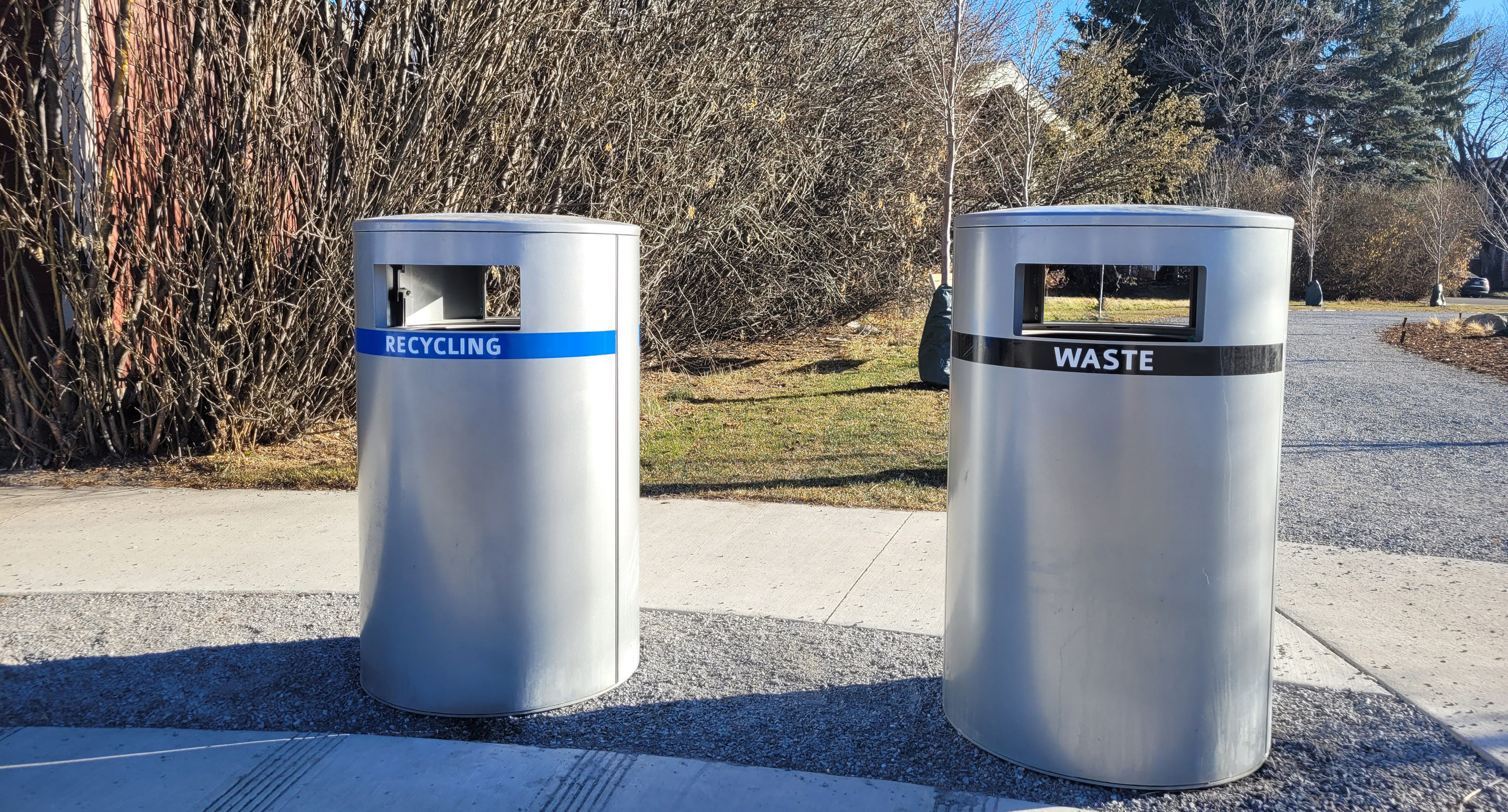 Deux poubelles argentées à l'extérieur, étiquetées 