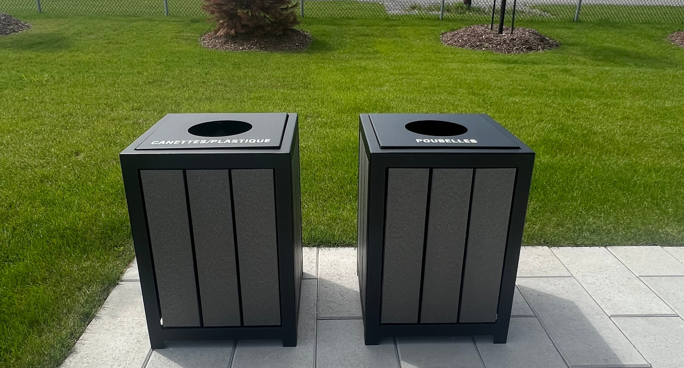 maglin_mtr-1050-trash-receptacles-1 Deux poubelles noires d'extérieur sur un patio ; la poubelle de gauche étiquetée