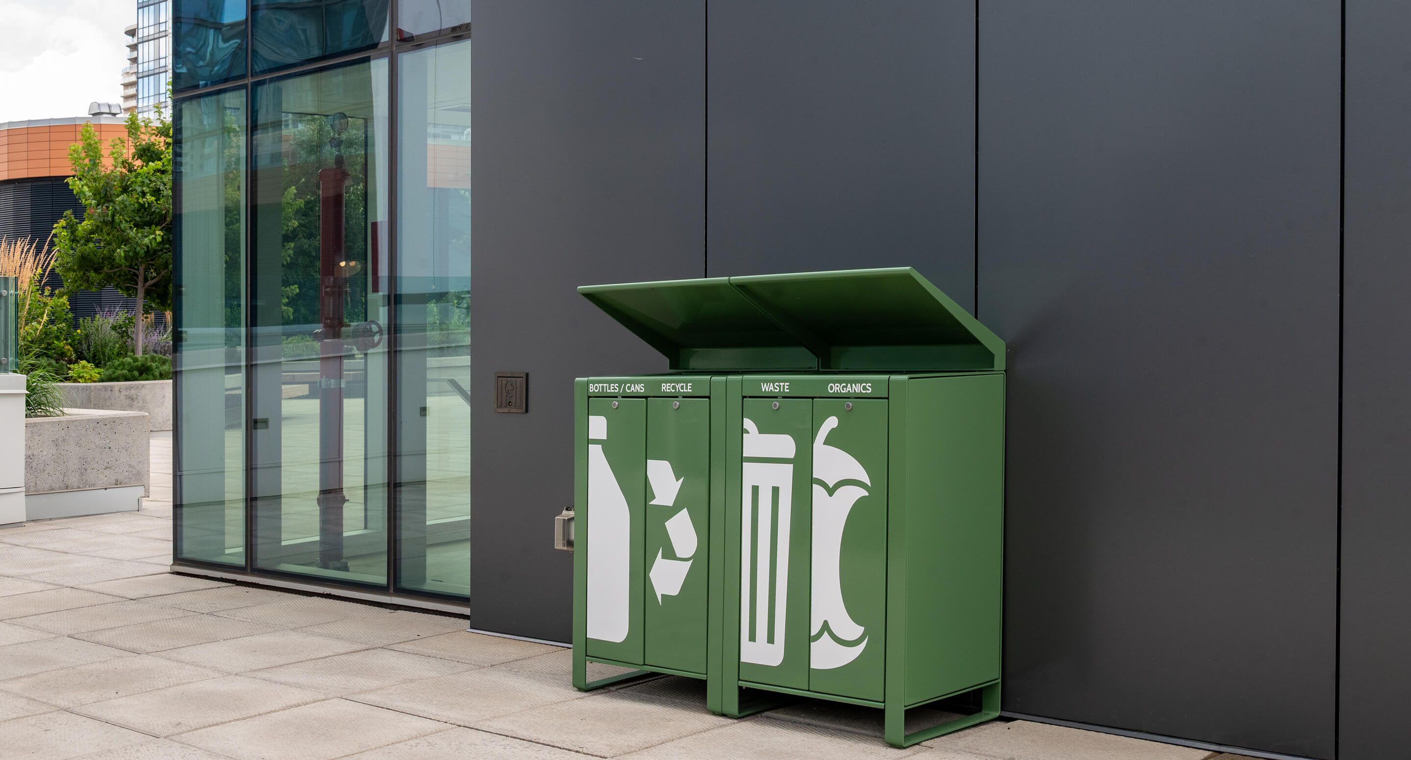 Three green outdoor bins labeled 