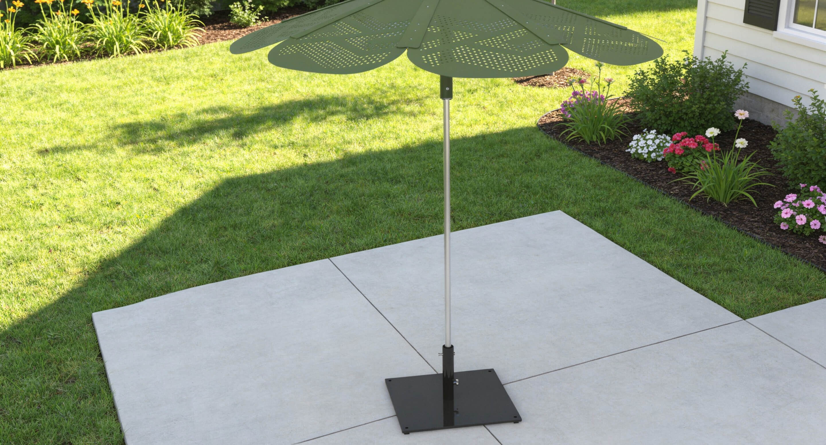 Reseda green ROMA sun shade and base with a leaf-like design stands on a concrete patio in a backyard with grass, flower beds, and a house wall.