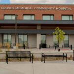Exterior view of Groves Memorial Community Hospital showcasing the hospital’s brick building, benches, trees, and bike racks on a clear day. Groves Memorial Community Hospital’s welcoming exterior creates a peaceful and inviting atmosphere for patients and visitors alike.
