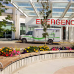A patient transport van parked under the Emergency Department entrance at Grace Hospital.